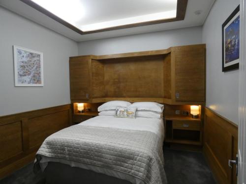 a bedroom with a large bed with a wooden headboard at Lorne View in Oban