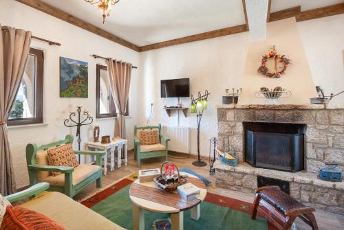 Villa Dianne Apt 1 Livadi Arachovas في أراخوفا: غرفة معيشة مع موقد حجري وكراسي خضراء