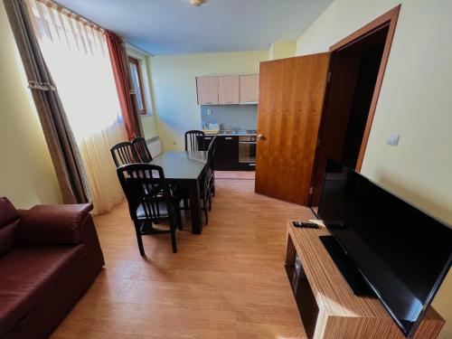 sala de estar con sofá y mesa con sillas en Апартаменти Замъците en Pamporovo