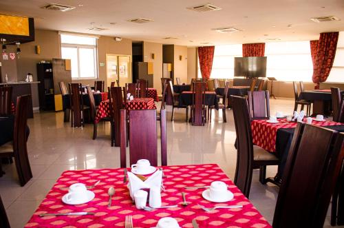 uma sala de jantar com mesas e cadeiras com toalha de mesa vermelha em Hotel Ceibo Dorado em Portoviejo
