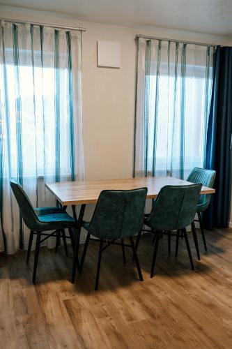 a table and chairs in a room with windows at Dill Apartments Ilsede in Ilsede