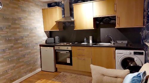 uma cozinha com um lavatório e uma máquina de lavar roupa em Lovely Centralised 1Bed Apt Near Town Centre & Beach - Free Wi-Fi & Parking em Fleetwood