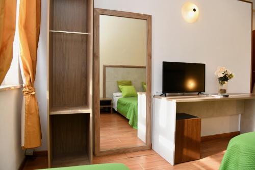 ローマにあるホテル アナカプリのベッドルーム(鏡、ベッド、テレビ付)