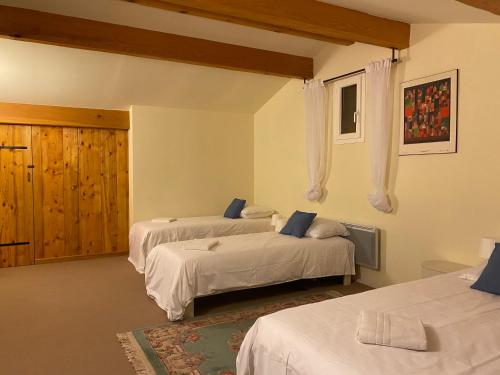 a bedroom with two beds with white sheets at La Peyreyre in Jaujac