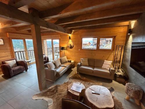 a living room with a couch and a table at Chalet des Cîmes, chaleureux avec jacuzzi et sauna in Gérardmer