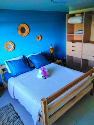 - une chambre avec un grand lit aux murs bleus dans l'établissement Bas de villa le rêve éveillé, à Le Robert