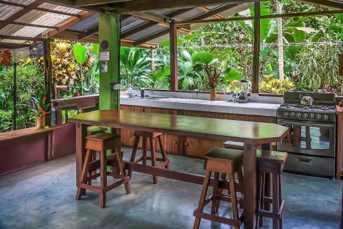 a kitchen with a wooden table and a stove at Casa Aire Libre in Puerto Jiménez