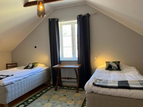 a attic room with two beds and a window at Sjögården in Vadstena