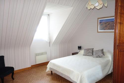 sypialnia z białym łóżkiem i oknem w obiekcie Spacieuse maison typique pour 10 personnes Vue mer plage à 10 minutes à pied- idéale pour des vacances ou un weekend en famille ou entre amis w mieście Étables