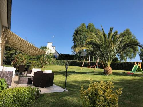 une cour avec une aire de jeux et un palmier dans l'établissement Spacieuse maison typique pour 10 personnes Vue mer plage à 10 minutes à pied- idéale pour des vacances ou un weekend en famille ou entre amis, à Étables