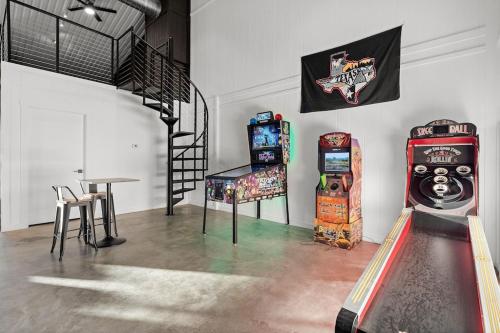 une chambre avec deux machines de jeux vidéo, une table et un drapeau dans l'établissement NEW-3 Properties on 10 acres sleeps 20 - Fun!!, à Hammetts Crossing