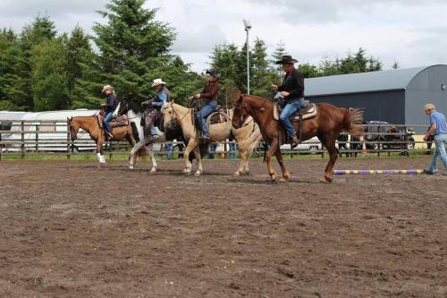 a group of people riding horses in an arena at Fern Lodge. Drumcoura Lake Resort, in Ballinamore