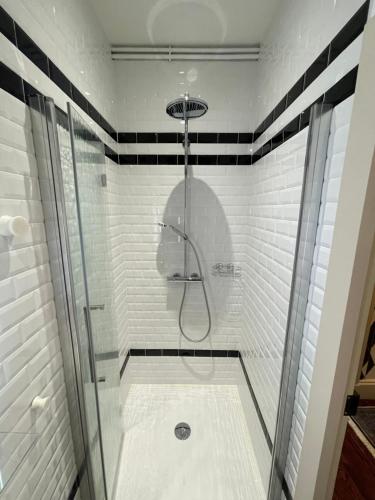 łazienka z prysznicem wyłożonym czarno-białymi kafelkami w obiekcie Maison Pignol w mieście Le Puy-en-Velay