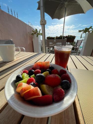 une assiette de fruits sur une table avec une boisson dans l'établissement Ca' de Tobia, à Noli