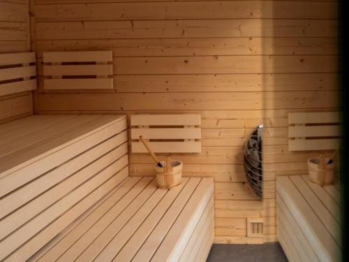 a wooden sauna with two benches and two paddles at Cabin Westerwald Sauna, 5G Internet, E-Ladesäule in Niederdreisbach