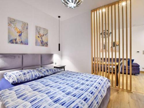 a bedroom with a blue and white bed and a desk at VILLA MILA Apartamenty in Karpacz