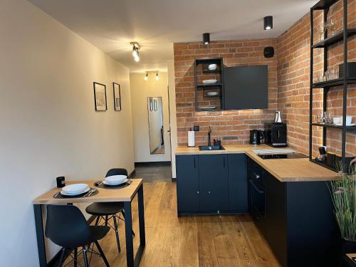 a kitchen with blue cabinets and a brick wall at PM. Apartments Krakow in Kraków