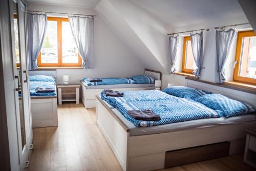 a bedroom with two beds and two windows at Chalupa U Juráša in Horní Bečva