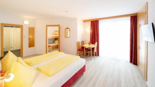 a hotel room with a bed and a table at Pension Helios in Sankt Kanzian