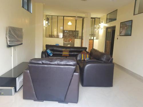 2 sofás de cuero sentados en una sala de estar en Bel appartement au centre ville de calavi BENIN, en Abomey-Calavi