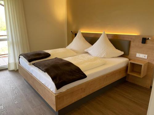 Schlafzimmer mit einem Bett mit weißer Bettwäsche und Kissen in der Unterkunft Haus Schatzgarten in Traben-Trarbach
