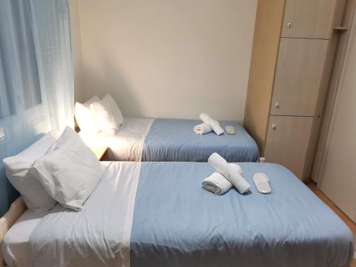 two beds in a hotel room with towels on them at EstellApartments in Athens
