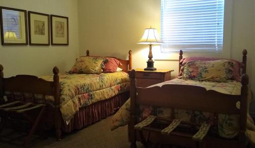a bedroom with two beds and a lamp and a window at Dogwood Springs Lodgings in Mineola