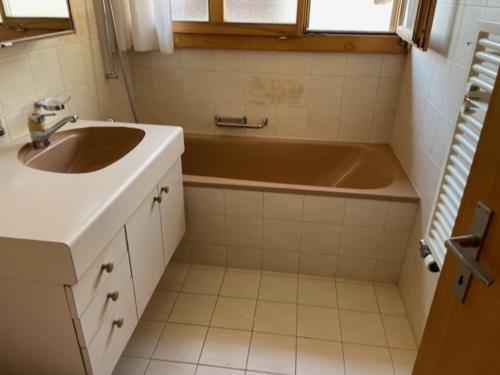 ein Badezimmer mit einem Waschbecken und einer Badewanne in der Unterkunft Wohnung in Sigriswil