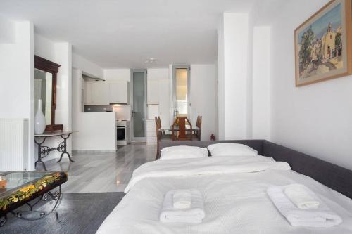 uma grande cama branca num quarto com uma cozinha em Psyris Marble Loft ! em Atenas