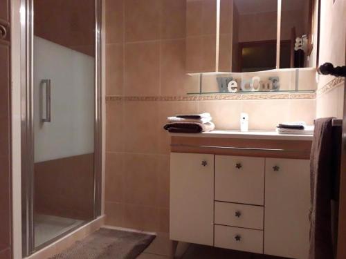a bathroom with a shower and a sink and a mirror at Belle de Dune in La Baule