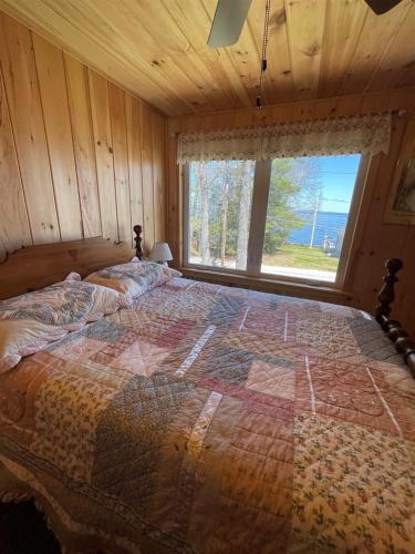 uma cama grande num quarto com uma janela em ROCKY'S LAKE HOUSE-LIMIT 6 home em Standish