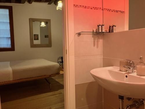 een badkamer met een wastafel en een bed bij Residenza Corte Antica in Venetië