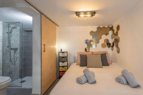 - une chambre avec un lit avec deux oreillers et une douche dans l'établissement Unique studio loft, walking distance to Valletta, à Hamrun