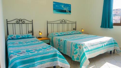 two beds sitting next to each other in a bedroom at Appartamento sette posti vicino al centro di San Teodoro in San Teodoro