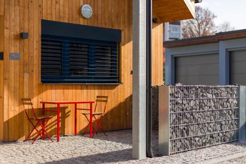 a red table and chairs in front of a building at Apartmány Kopacka in Svitavy