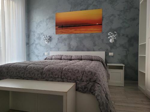a bedroom with a bed and a painting on the wall at Casa Mara in Chioggia