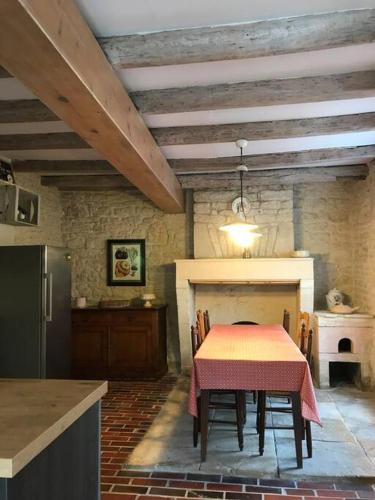 une salle à manger avec une table et une cheminée dans l'établissement Grand gîte au calme avec piscine, à Ardillières
