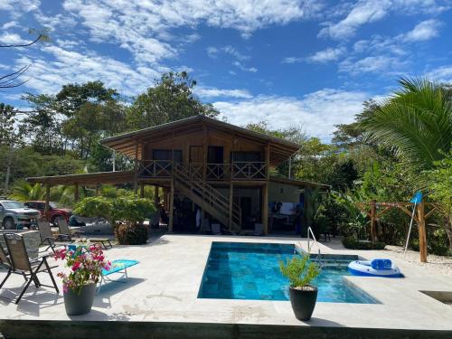 a house with a swimming pool in front of it at Casa Gratitud in Paquera
