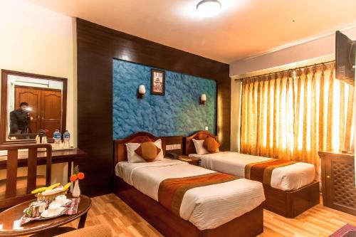 a hotel room with two beds and a table at Samsara Boutique Hotel in Kathmandu