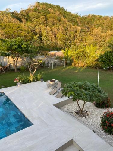 a backyard with a swimming pool and a garden at Casa Gratitud in Paquera