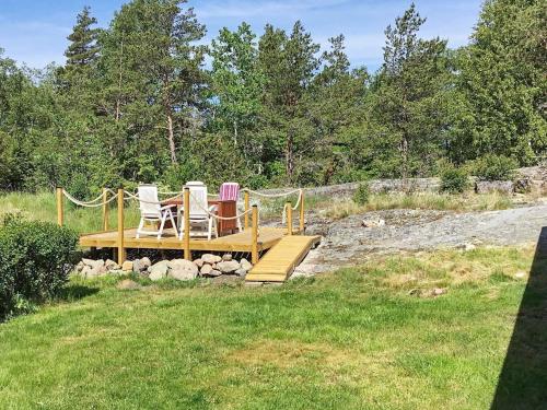 two chairs sitting on a wooden bridge in the grass at 7 person holiday home in LUR in Lur