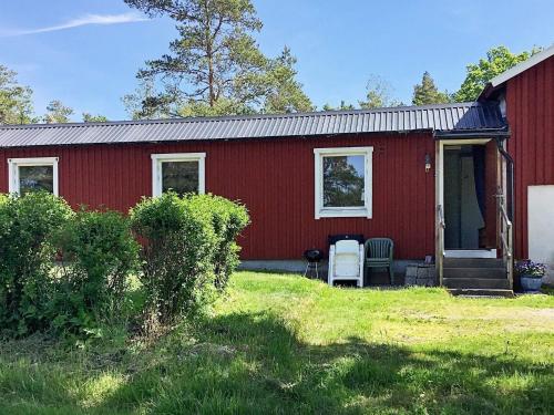 a red house with a porch and chairs in front of it at 7 person holiday home in LUR in Lur