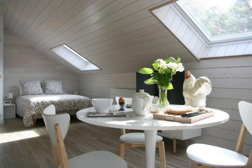 Cette chambre mansardée comprend une table et un lit. dans l'établissement Home Kervezec, à Garlan