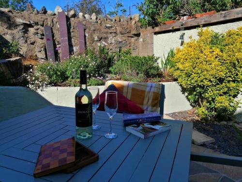 - une bouteille de vin et un verre sur une table dans l'établissement Lovely Stone Village cottage in Snowdonia, à Waenfawr