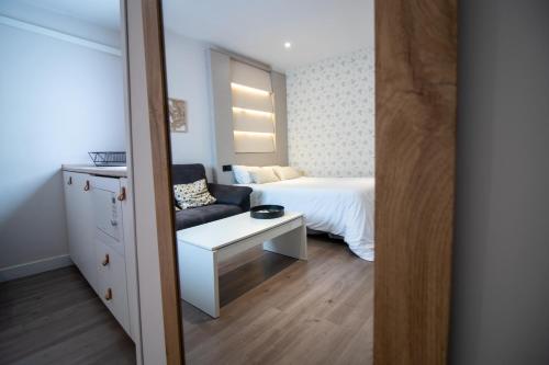 グラナダにあるApartamento moderno en el centro de Granada - Mititillaのベッドルーム(ベッド1台、ソファ、鏡付)
