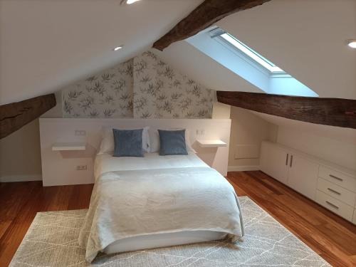 a bedroom with a bed in a attic at Casa a Antiga Tenda in Santiago de Compostela