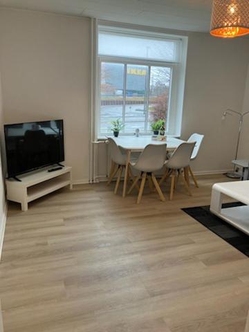a living room with a television and a table and chairs at Gentofte København in Gentofte