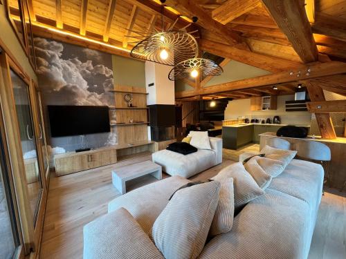 a living room with two couches and a flat screen tv at Châlets AOKI in Valloire