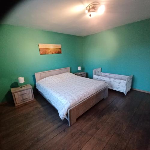 a bedroom with a bed and a green wall at Gite Au Cortil in Chevetogne