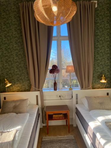 1 dormitorio con 2 camas y ventana en Klostergårdens Vandrarhem, en Varnhem